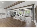 Spacious living room with wood-look floors, neutral furniture, large windows, and a view to the backyard at 10529 Pleasant Branch Dr # 201, Raleigh, NC 27614