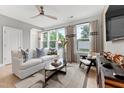 Bright living room featuring large windows, neutral decor, a ceiling fan, and a comfortable white sofa at 10531 Pleasant Branch Dr # 101, Raleigh, NC 27614