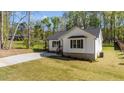Side view of white house with manicured lawn on a sunny day at 132 Prairie Dog Dr, Louisburg, NC 27549