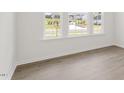 Bright bedroom with large windows, neutral walls, and hardwood floors at 1688 Abberly Pl, Graham, NC 27253