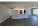 Bright, open-concept kitchen featuring a large island, pendant lighting, and modern appliances at 200 Rawhide Dr, Louisburg, NC 27549