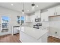 Well-lit kitchen featuring white cabinets, stainless steel appliances, and pendant lighting at 909 Montague Ave, Durham, NC 27703