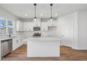 Bright kitchen features white cabinetry, stainless steel appliances, and a quartz island at 909 Montague Ave, Durham, NC 27703