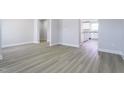 Open-concept space with light vinyl floors, white trim, and easy access to the kitchen at 105 Wilderness Ct, Mebane, NC 27302