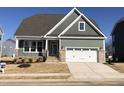 Charming green two-story home with a well-manicured lawn, brick-lined driveway, and a two-car garage at 1600 Maelyn Way, Fuquay Varina, NC 27526