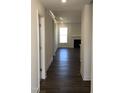 Inviting hallway with hardwood floors leads to a living room with a fireplace and a large bright window at 1600 Maelyn Way, Fuquay Varina, NC 27526