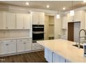 Bright kitchen featuring stainless steel appliances, elegant quartz countertops, and white cabinets at 1600 Maelyn Way, Fuquay Varina, NC 27526