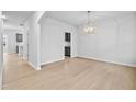 Bright dining room with wood floors and stylish light fixture, with a partial view into an adjacent area at 2750 Lacy Holt Rd, Graham, NC 27253