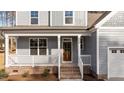 Front porch with brick steps leading to a wood front door at 35 Arbor Dr, Youngsville, NC 27596