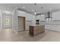 Spacious kitchen featuring white cabinetry, stainless steel appliances, and a center island with granite countertop at 35 Arbor Dr, Youngsville, NC 27596