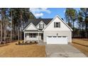Two-story house with gray siding, white garage door, and landscaping at 75 Arbor Dr, Youngsville, NC 27596