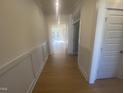 Bright hallway with light wood flooring and white wainscoting at 110 Sawtooth Oak Ln, Youngsville, NC 27596
