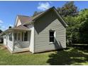 Side view of a charming home with neutral siding and brown roof, showcasing its simple architecture and well-maintained exterior at 1200 Carolina St, Graham, NC 27253