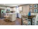 Modern kitchen with white cabinets, island, and dining area at 600 Mathiola Dr, Wendell, NC 27591