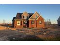 Newly constructed two-story brick house with black shutters, a gray roof, and double peak architecture at 7575 Sweetwater Dr, Nashville, NC 27856