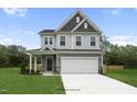 Two-story home with gray siding, white trim, and a two-car garage at 8816 Melvin St # 15, Willow Springs, NC 27592