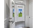 A view of the front door from the foyer, with neutral wall and trim colors at 8816 Melvin St # 15, Willow Springs, NC 27592