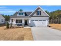 Charming single-Gathering home featuring a welcoming two-car garage and inviting covered front porch with stone accents at 91 Laramie Ln, Selma, NC 27576