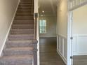 Inviting foyer with carpeted stairs and wood flooring, showcasing the home's transition to living spaces at 113 Arundel Dr, Archer Lodge, NC 27527