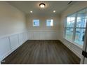 Bright living room featuring modern wainscoting, hardwood floors, and large windows for natural light at 113 Arundel Dr, Archer Lodge, NC 27527