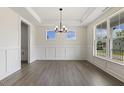 A bright dining room with hardwood floors, a chandelier, large windows, and decorative molding at 115 Arundel Dr, Archer Lodge, NC 27527