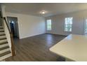 Open living room showcasing hardwood floors, natural light from two windows, and modern design features at 115 Arundel Dr, Archer Lodge, NC 27527