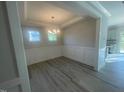 Elegant dining room featuring wainscoting, a modern chandelier, and ample natural light at 116 Arundel Dr, Archer Lodge, NC 27527