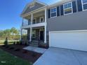 Two-story home featuring a double porch, neutral siding, well-kept lawn, and attached two car garage at 118 Arundel Dr, Archer Lodge, NC 27527