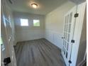Office with two windows, gray wood floors, and white wainscoting at 118 Arundel Dr, Archer Lodge, NC 27527