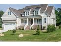 Attractive two-story home boasts a covered porch, manicured lawn and neutral color palette at 1233 Azalea Garden Cir, Raleigh, NC 27603