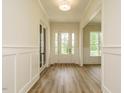 Bright foyer with hardwood floors, white trim, paneled walls, and a glass-paneled front door at 1233 Azalea Garden Cir, Raleigh, NC 27603