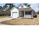 Charming white home with an attached garage, gray door, wooden pillars and shutters, and freshly installed sod at 5093 Nc 56 Hwy, Franklinton, NC 27525