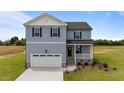 Charming two-story home featuring a covered porch, attached garage, and beautifully landscaped front yard at 55 Diamond Creek Dr, Zebulon, NC 27597