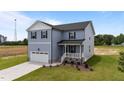 Charming two-story home featuring a covered porch, attached garage, and beautifully landscaped front yard at 55 Diamond Creek Dr, Zebulon, NC 27597