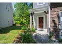 Inviting front entryway with decorative door and surrounding landscaped garden at 809 Davidson Point Rd, Cary, NC 27513