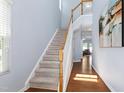Bright foyer features hardwood flooring, a carpeted staircase, and natural light at 809 Davidson Point Rd, Cary, NC 27513
