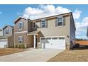 Two-story house with tan and brown siding, two-car garage at 332 Squirrel Oaks Ln, Garner, NC 27529