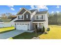 Two-story home featuring a gray facade, two-car garage, and well-maintained lawn, showcasing curb appeal at 41 Red River Dr, Selma, NC 27576