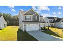 Gray two-story home with a two-car garage and well-kept lawn in a residential neighborhood at 41 Red River Dr, Selma, NC 27576