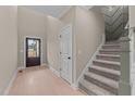 Bright entryway with hardwood floors, dark door, and carpeted staircase at 55 Basil Ct, Franklinton, NC 27525