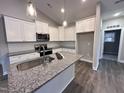 Modern kitchen featuring white cabinets, granite countertops, and stainless steel appliances at 927 Micro W Rd, Selma, NC 27576