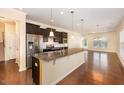 Open kitchen with granite counters, stainless steel appliances, and rich wood floors perfect for entertaining at 219 Rosedale Creek Dr, Durham, NC 27703