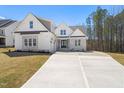 Beautiful new construction with a stone and white wood exterior, double front doors, and a large driveway at 617 Darian Woods Dr, Holly Springs, NC 27540