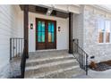 Stunning stone stairway and columns lead up to a beautiful wood front door with transom windows at 617 Darian Woods Dr, Holly Springs, NC 27540