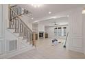 Open-concept living room with a fireplace, built-in shelving, and large windows, and a staircase at 617 Darian Woods Dr, Holly Springs, NC 27540