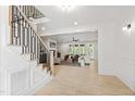 Bright, open living area with hardwood flooring, a staircase, and a view of the backyard at 617 Darian Woods Dr, Holly Springs, NC 27540
