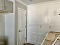 White paneled wall in kitchen with gray cabinets and built-in shelving at 6648 Sheriff Watson Rd, Sanford, NC 27332