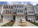 Townhomes with stone accents, garages, and coordinated color schemes line the driveways at 2325 Bay Minette Sta # 548, Apex, NC 27502