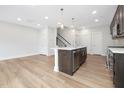 Bright kitchen featuring a central island with stainless appliances, and hardwood flooring at 324 Church St, Morrisville, NC 27560