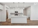 Modern kitchen featuring a center island, white cabinetry, stainless steel appliances, and wood-look flooring at 622 Brittany Ct, Durham, NC 27703